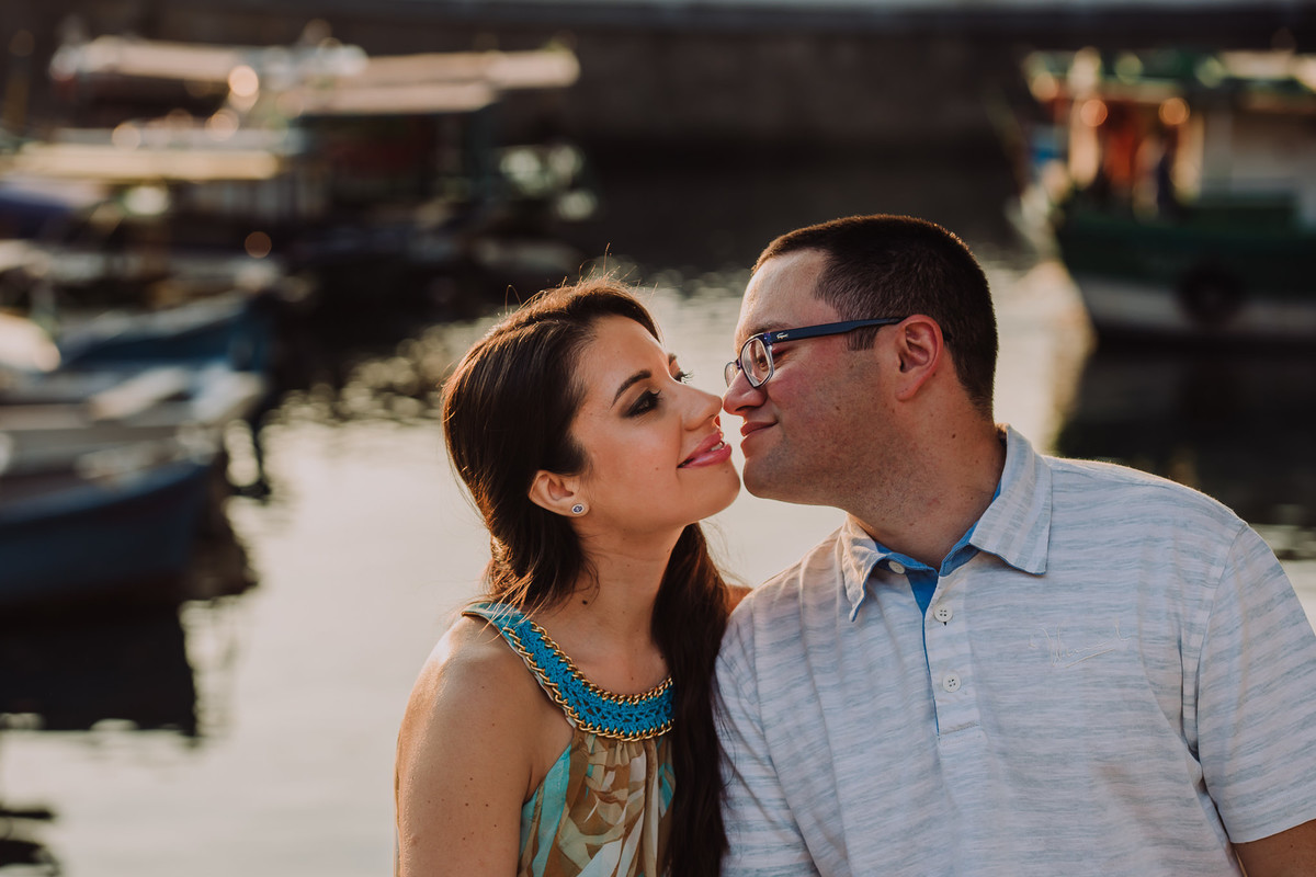 O noivo Raphael chegando para dar um beijo na sua noiva Bruna no ensaio pré-casamento no Quadrado da Urca, Rio de Janeiro/RJ