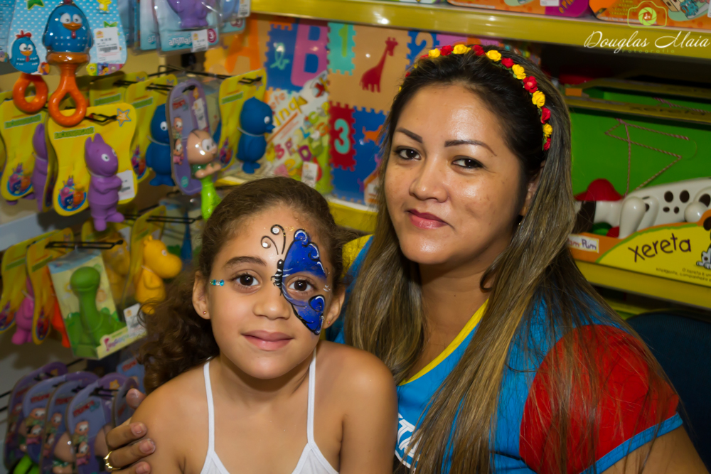 Menina com pintura de borboleta no rosto pelo fotógrafo Douglas Maia