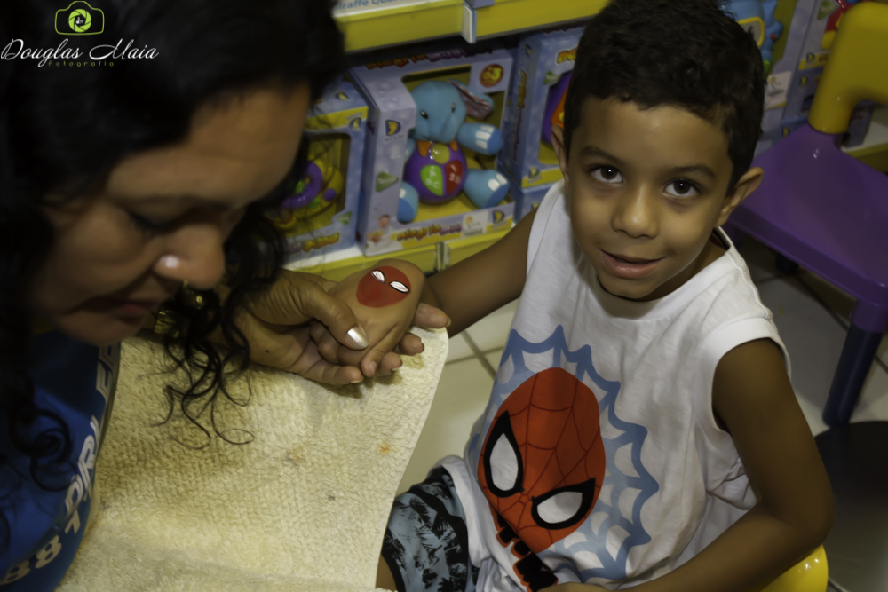 Menina pintando a mão Homem Aranha pelo fotógrafo Douglas Maia