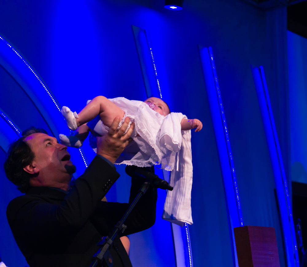 Pastor Simonton lenta a criança na apresentação de Crianças na Igreja Missão Praia da Costa pelo fotógrafo Douglas Maia