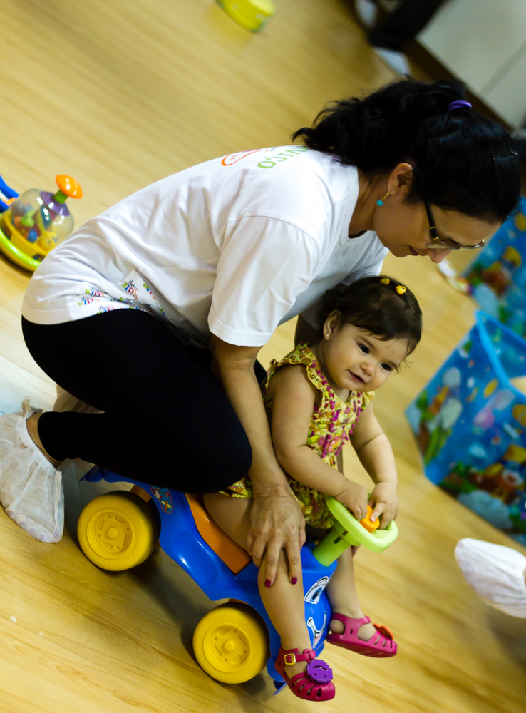 Tia cuidando de menina na salinha na Igreja Missão Praia da Costa pelo fotógrafo Douglas Maia