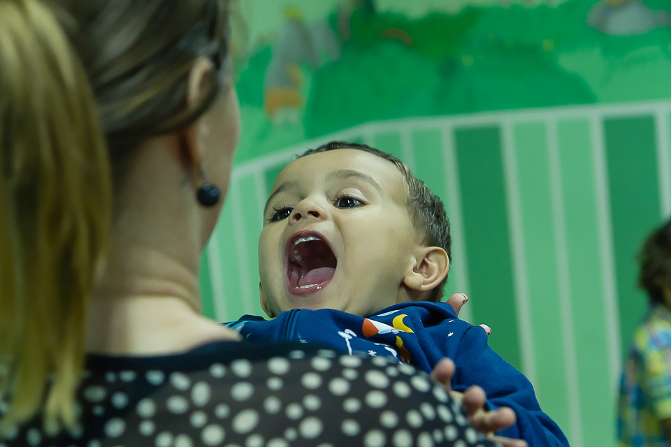 Menino brincando alegremente na salinha Igreja Missão Praia da Costa pelo fotógrafo Douglas Maia