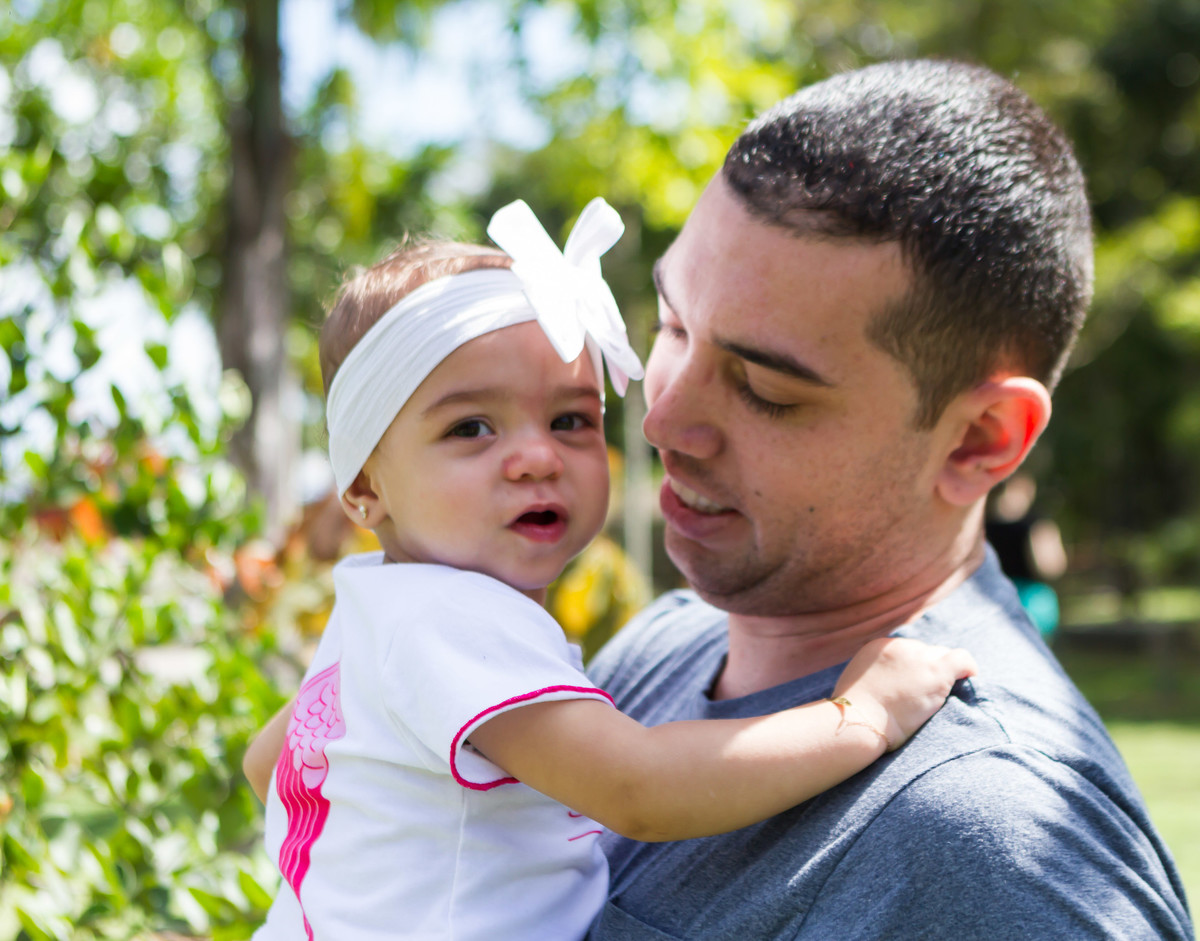 Luísa em segurança nos braços de seu pai pelo fotógrafo Douglas Maia