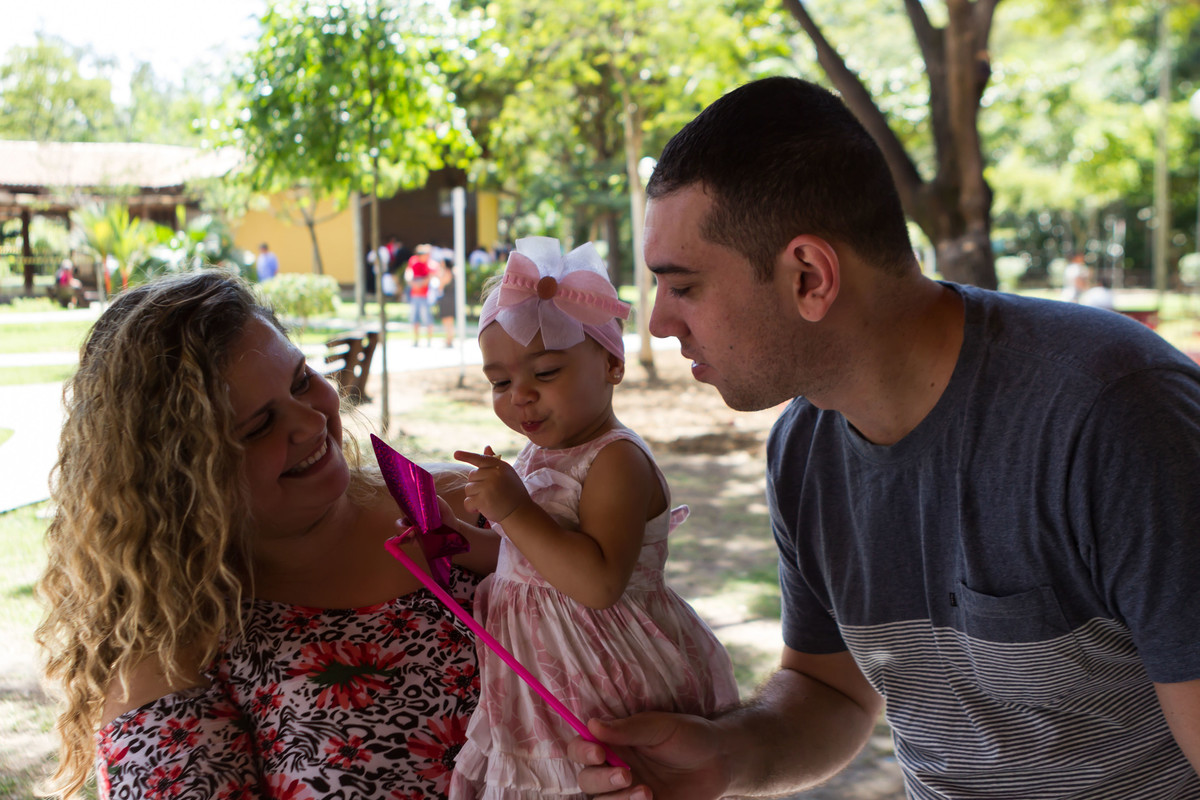 Luísa e sua família brincando com catavento pelo fotógrafo Douglas Maia