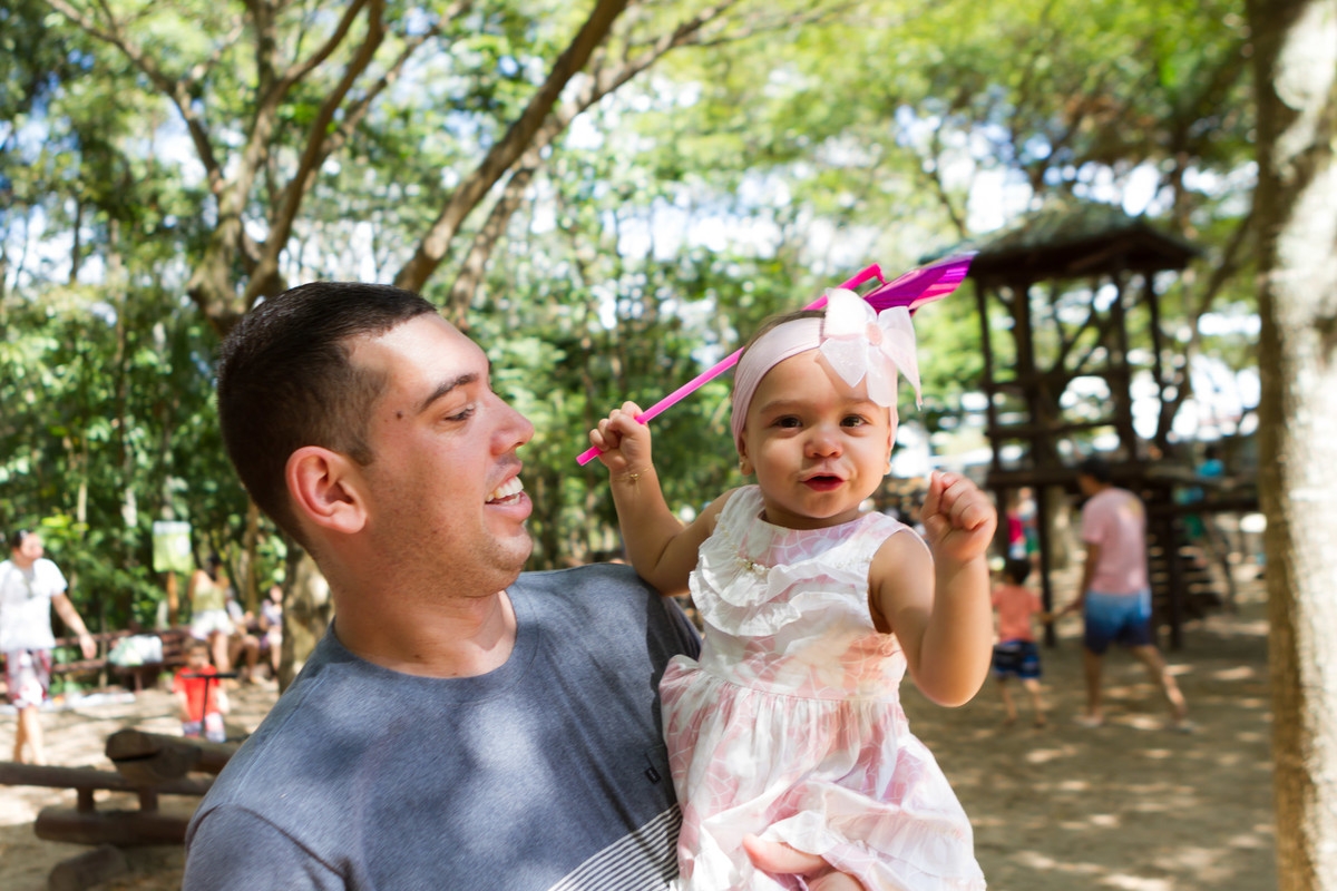Luísa segurando o catavento no colo do papai pelo fotógrafo Douglas Maia