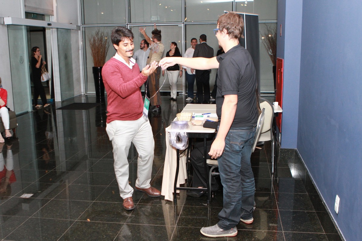 Homem recebendo seu crachá pelo fotógrafo Douglas Maia
