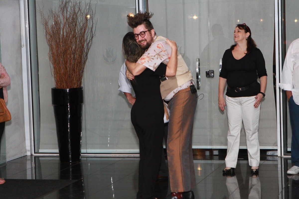 Mulher de preto recebe abraço pelo fotógrafo Douglas Maia