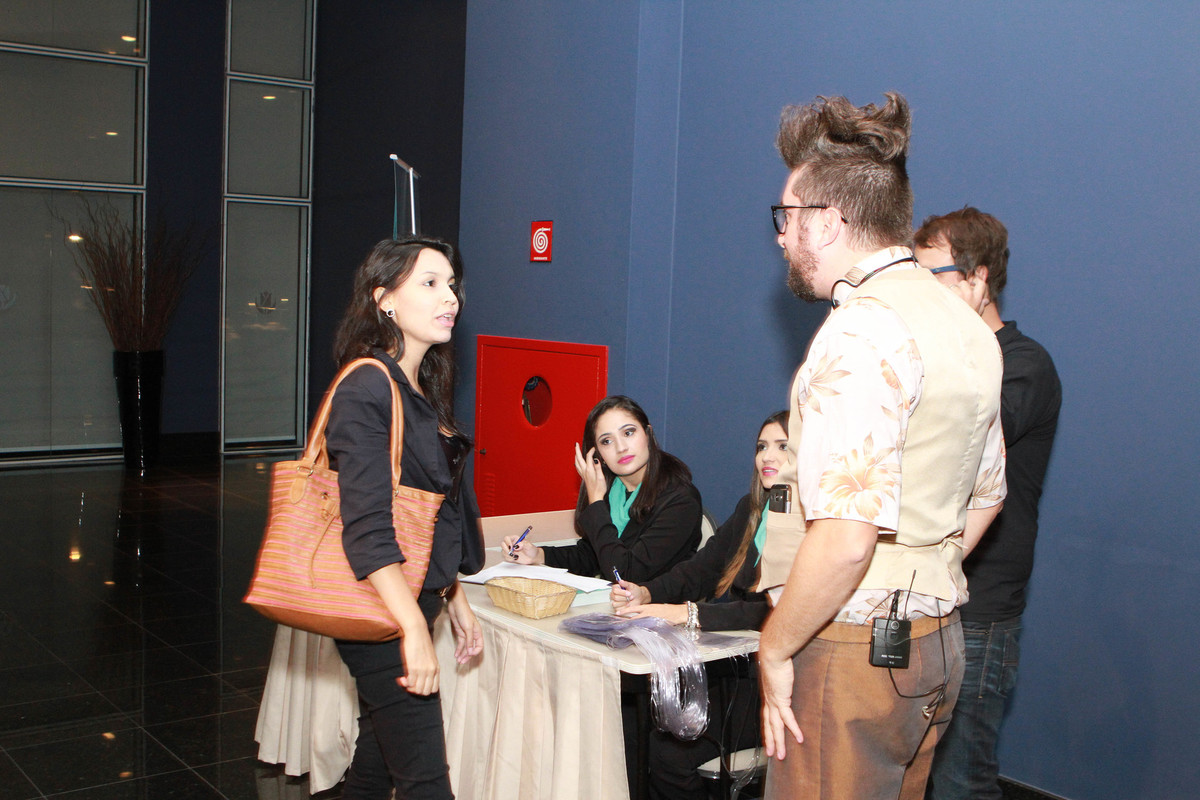 Mulher conversa com recepcionista pelo fotógrafo Douglas Maia