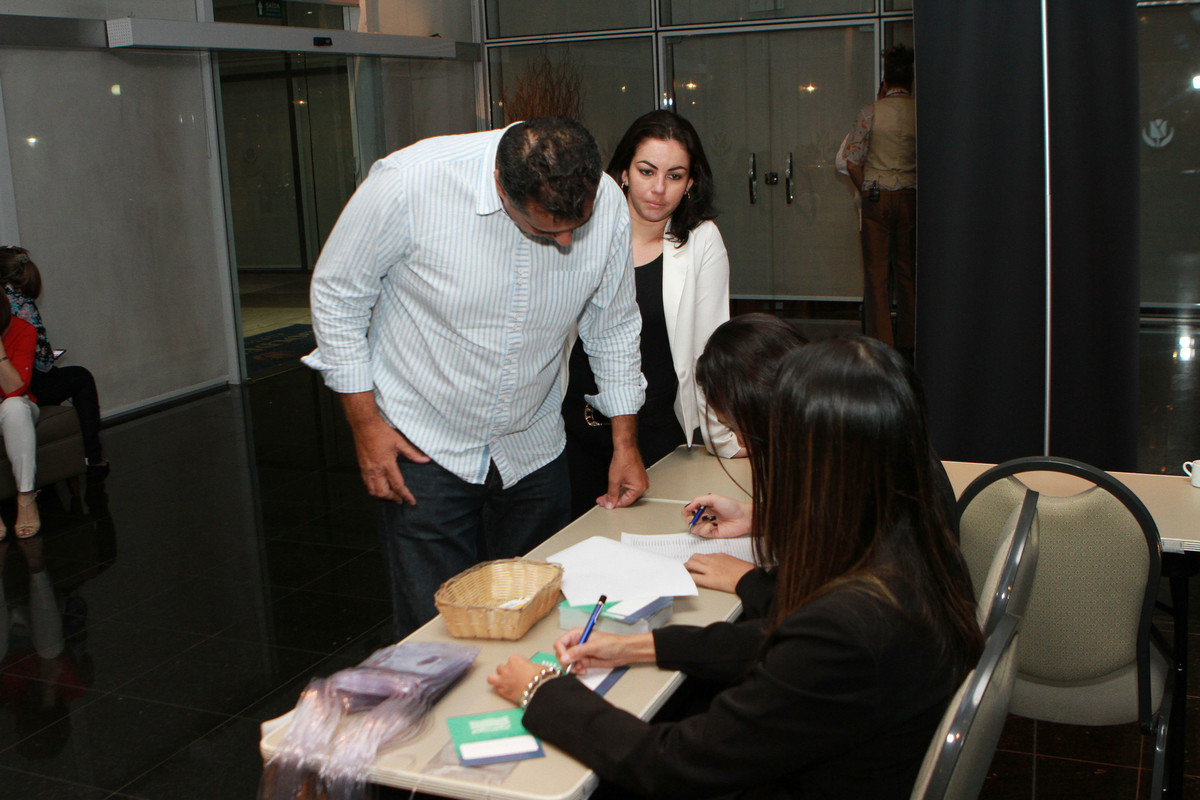 Homem conversa com recepcionista pelo fotógrafo Douglas Maia