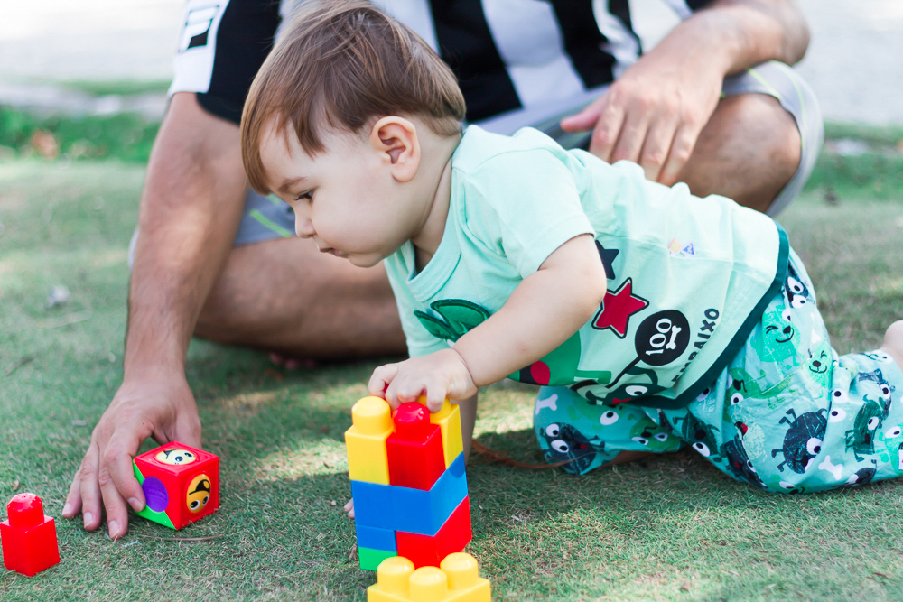 Caio brincando na grama pelo fotógrafo Douglas Maia