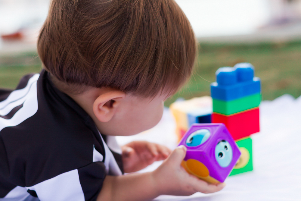 Caio com brinquedo na mão pelo fotógrafo Douglas Maia