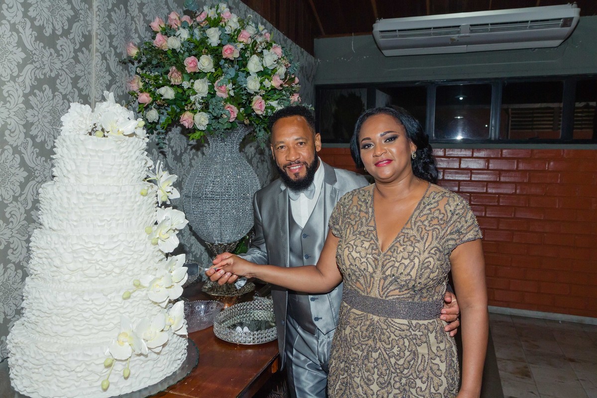Cláudia e Jefferson cortam o bolo Bodas de Prata pelo fotógrafo Douglas Maia