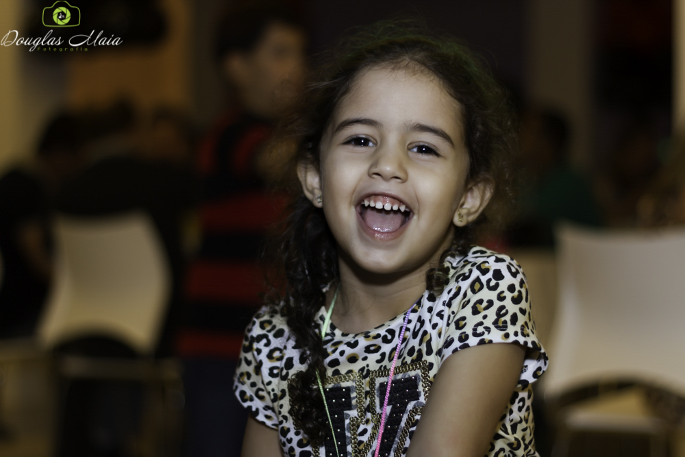 Menina sorrindo pelo fotógrafo Douglas Maia