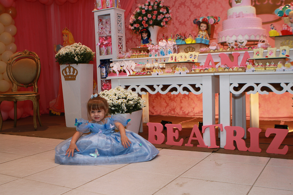 Ana Beatriz sentada no chão ao lado da mesa pelo fotógrafo Douglas Maia