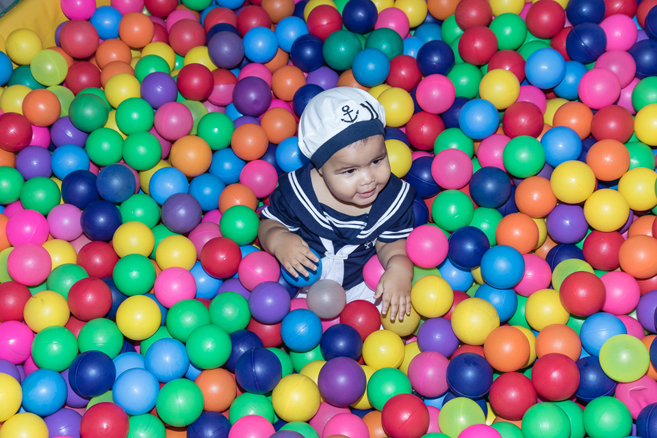 Arthur sorrindo na piscina de bolinhas pelo fotógrafo Douglas Maia