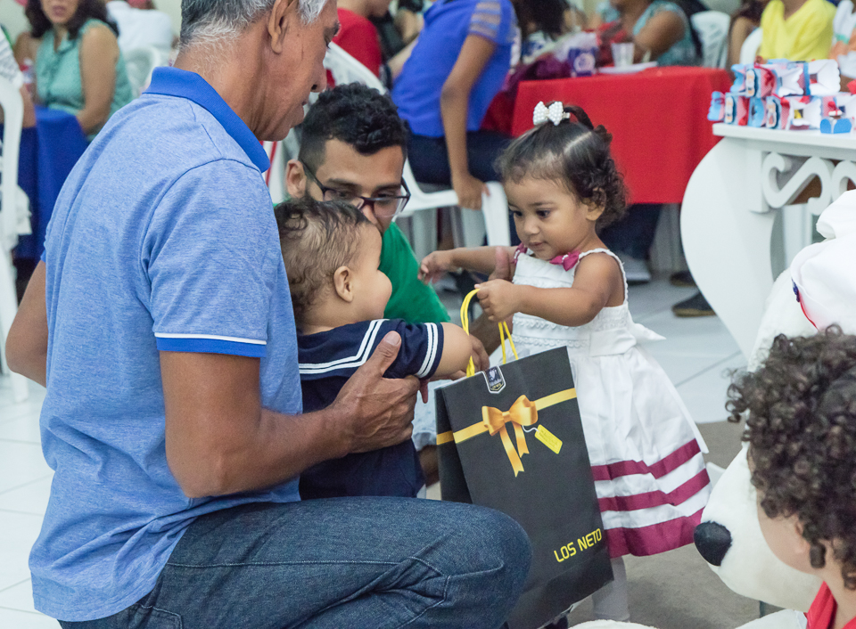 Menina entregando presente a Arthur pelo fotógrafo Douglas Maia