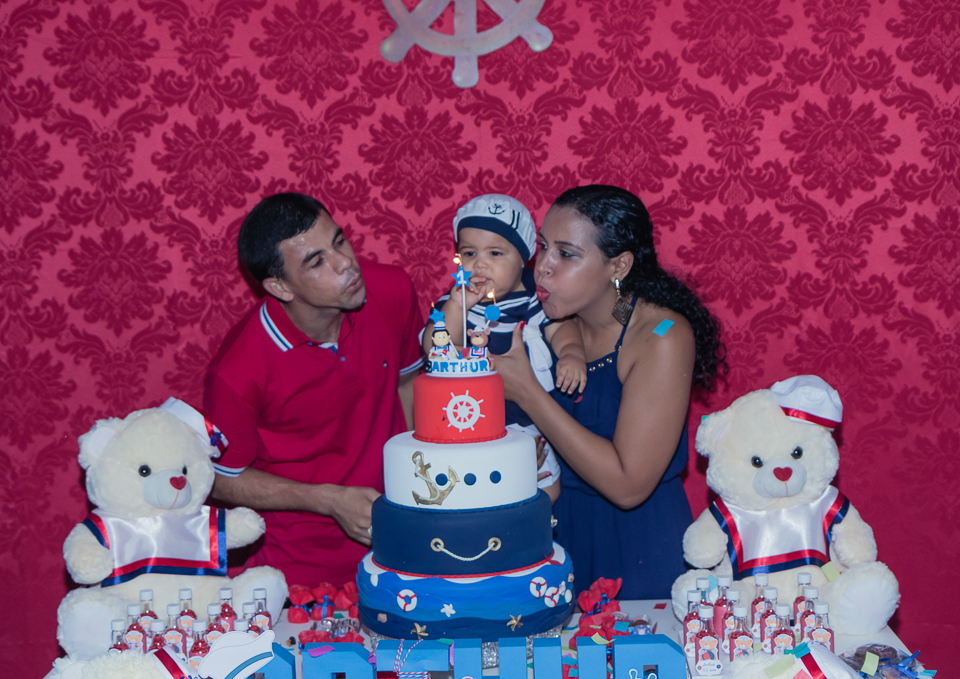 Arthur e seus pais soprando a vela pelo fotógrafo Douglas Maia