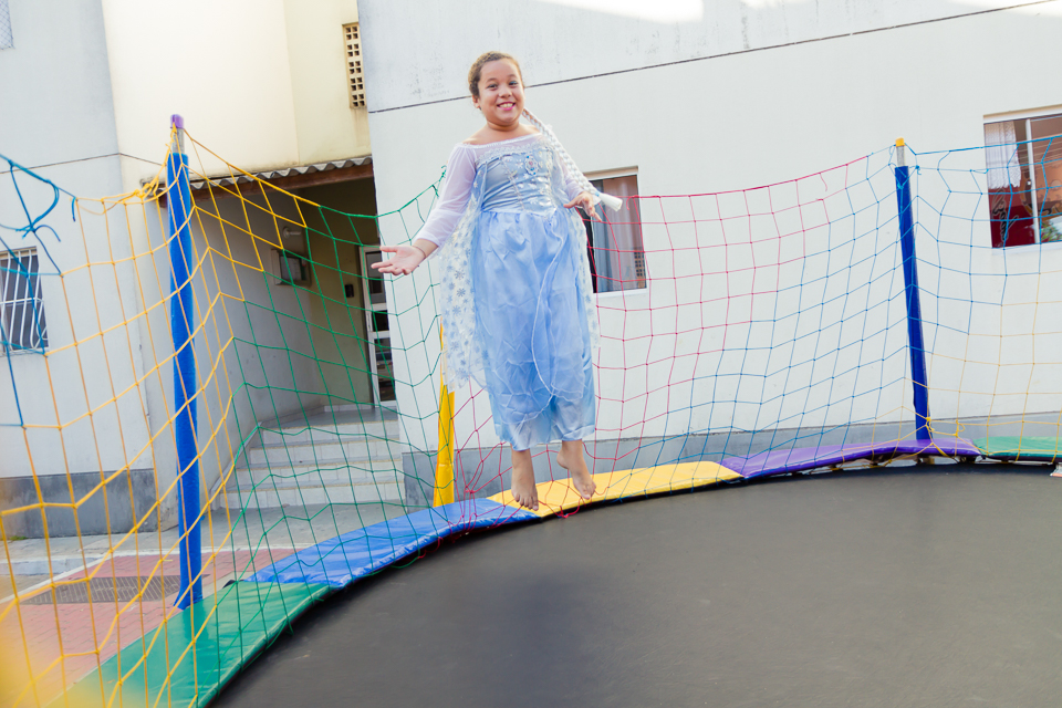 Duda sorrindo no pula pula pelo fotógrafo Douglas Maia