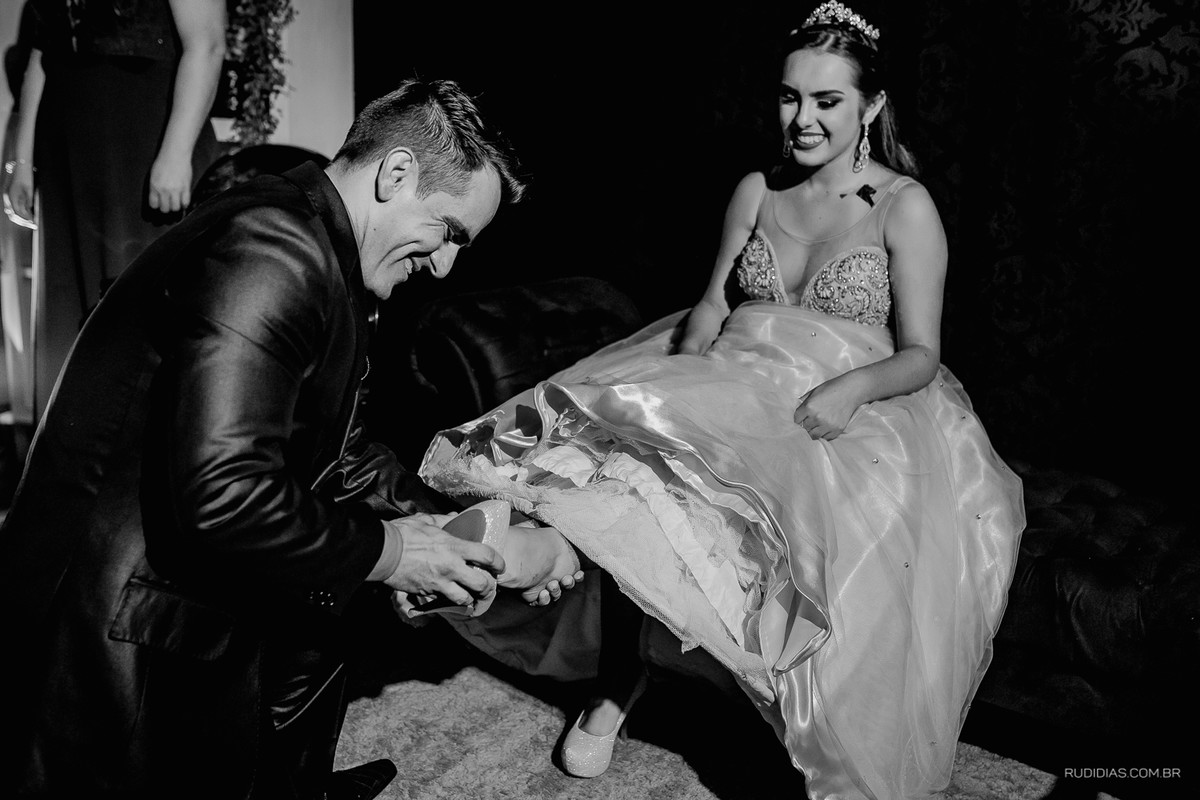 pai colocando o sapato de 15 anos em debutante