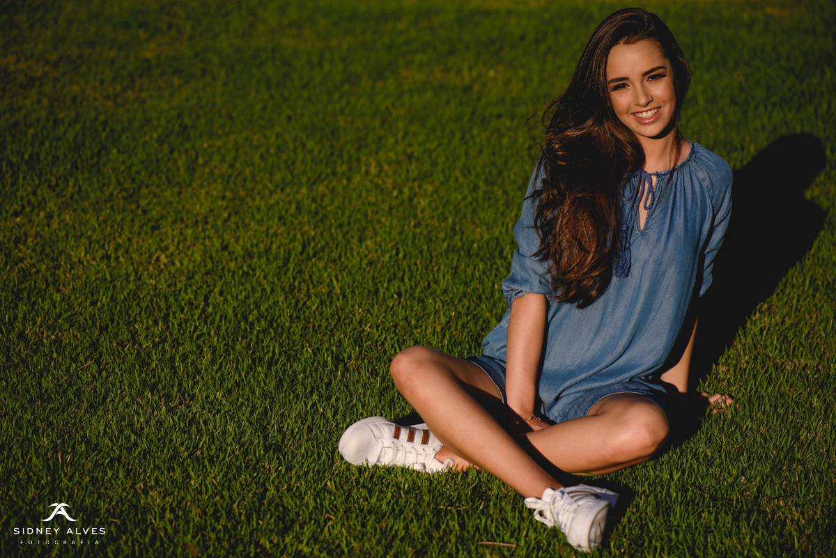 Mariana Cavalcanti sentada na grama