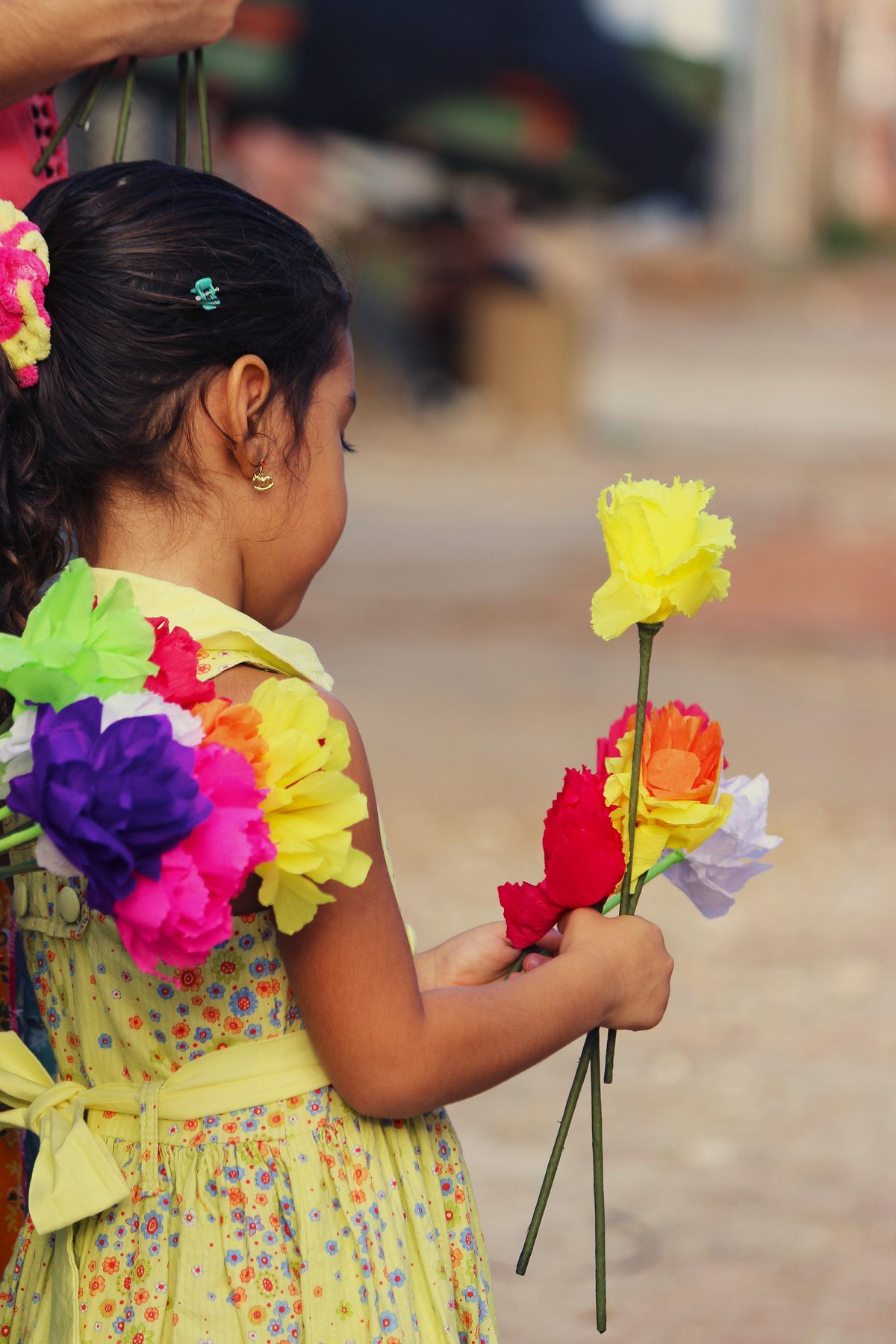 Criança com flores artesanais de papel