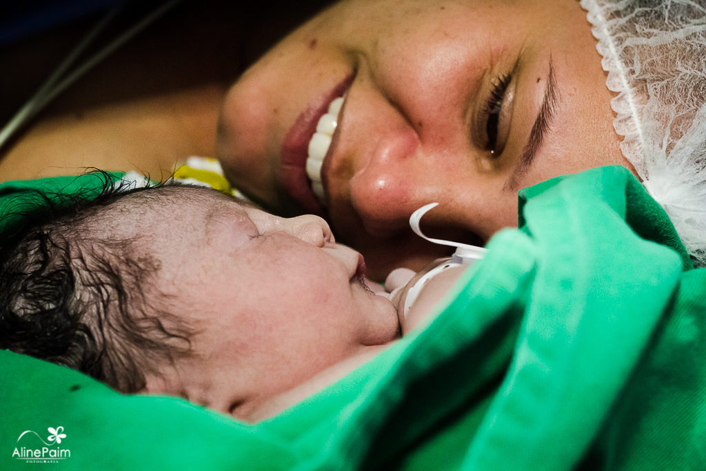 mamãe babando no seu bebezinho, logo após o nascimento, foto linda deste momento capturada pela fotografa de partos aline paim 