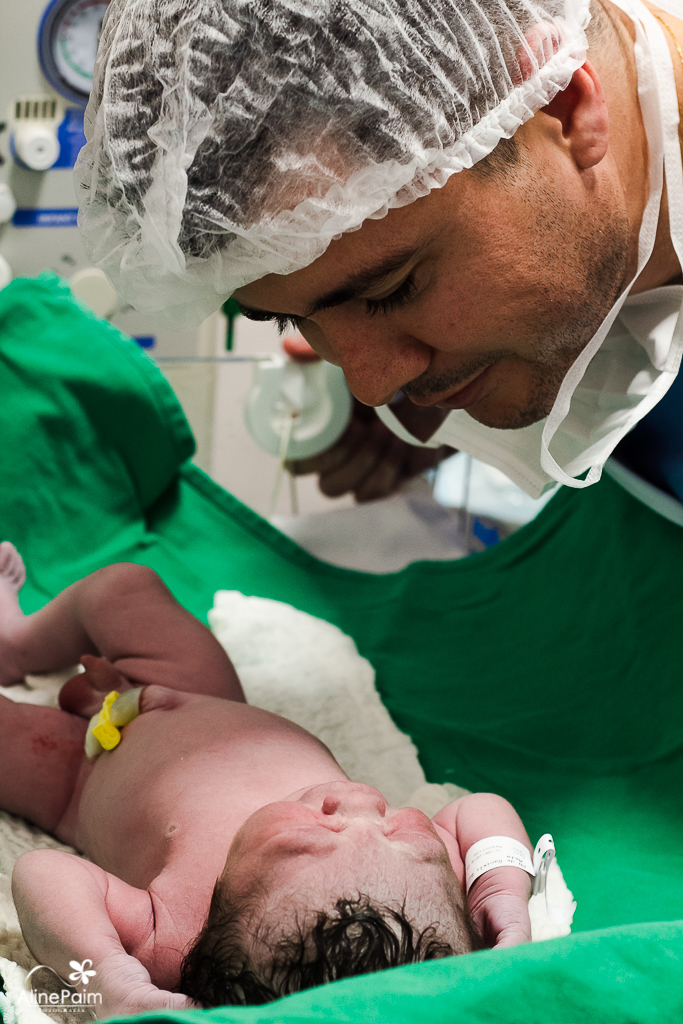 Papai só admirando o seu bebezinho, foto feita pela fotografa de partos aline paim