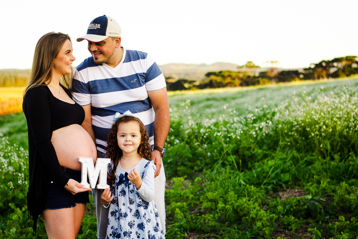 família feliz aguardando por seu bebezinho, fotografados pela fotografa aline paim fotografia em um ensaio externo em campo alegre em santa catarina