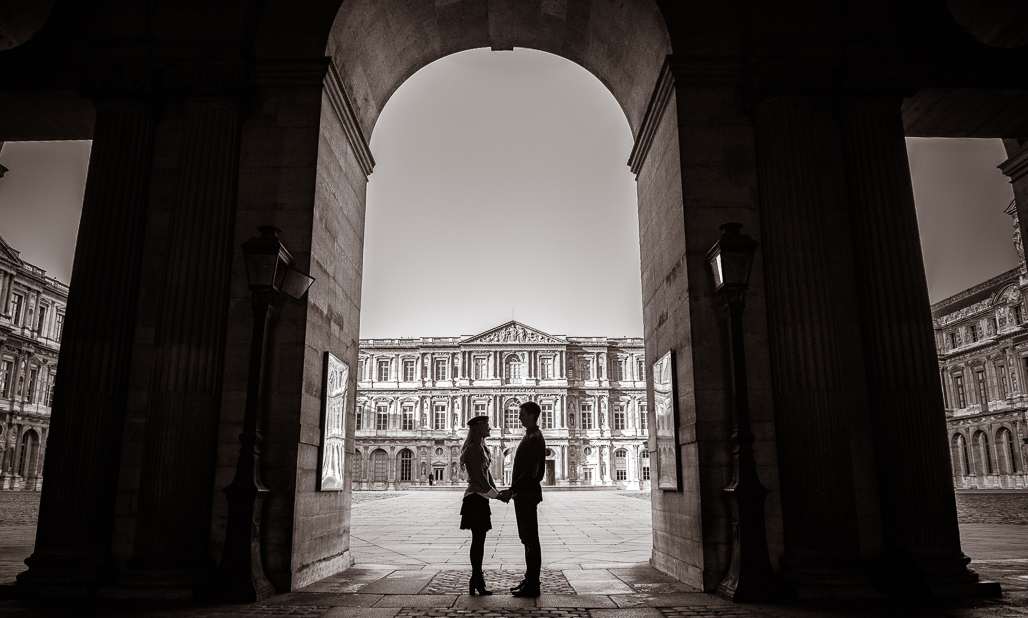 Casal apaixonado de mãos dadas no MUSEU DO LOUVRE sentados fotografado pelo FOTOGRAFO EM PARIS