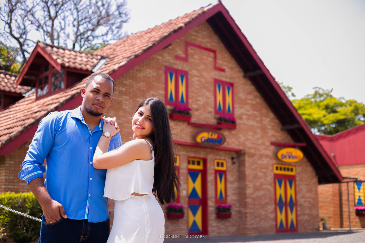 pose dos noivos na sessão de fotos em holambra, com uma casa de tijolos de fundo