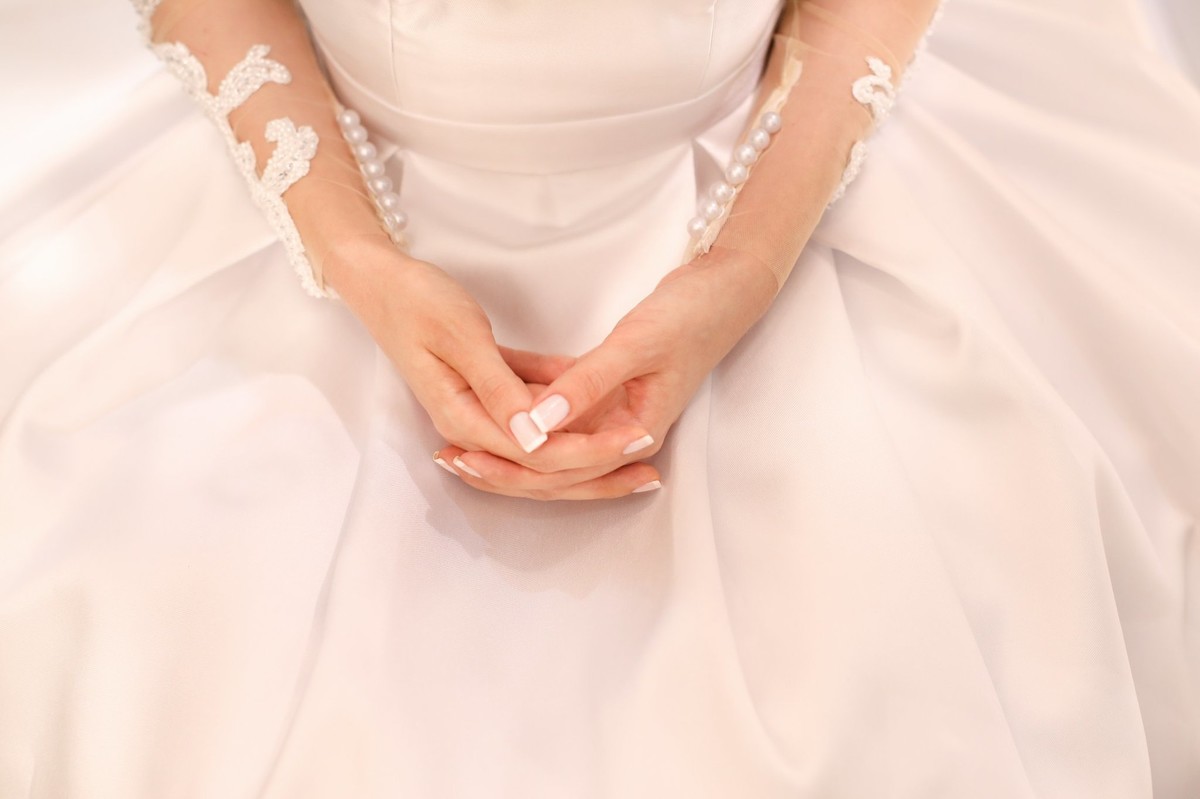 noiva ja vestida seu vestido mostrando detalhes da sua francesinha nas suas mao foto tirada pelo fotografo de casamento thiago alt