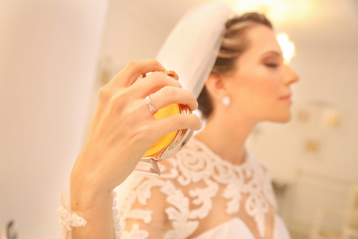 noiva passando seu perfume e mostrando o detalhe da sua alianca no dedo foto tirada pelo fotografo de casamento thiago alt