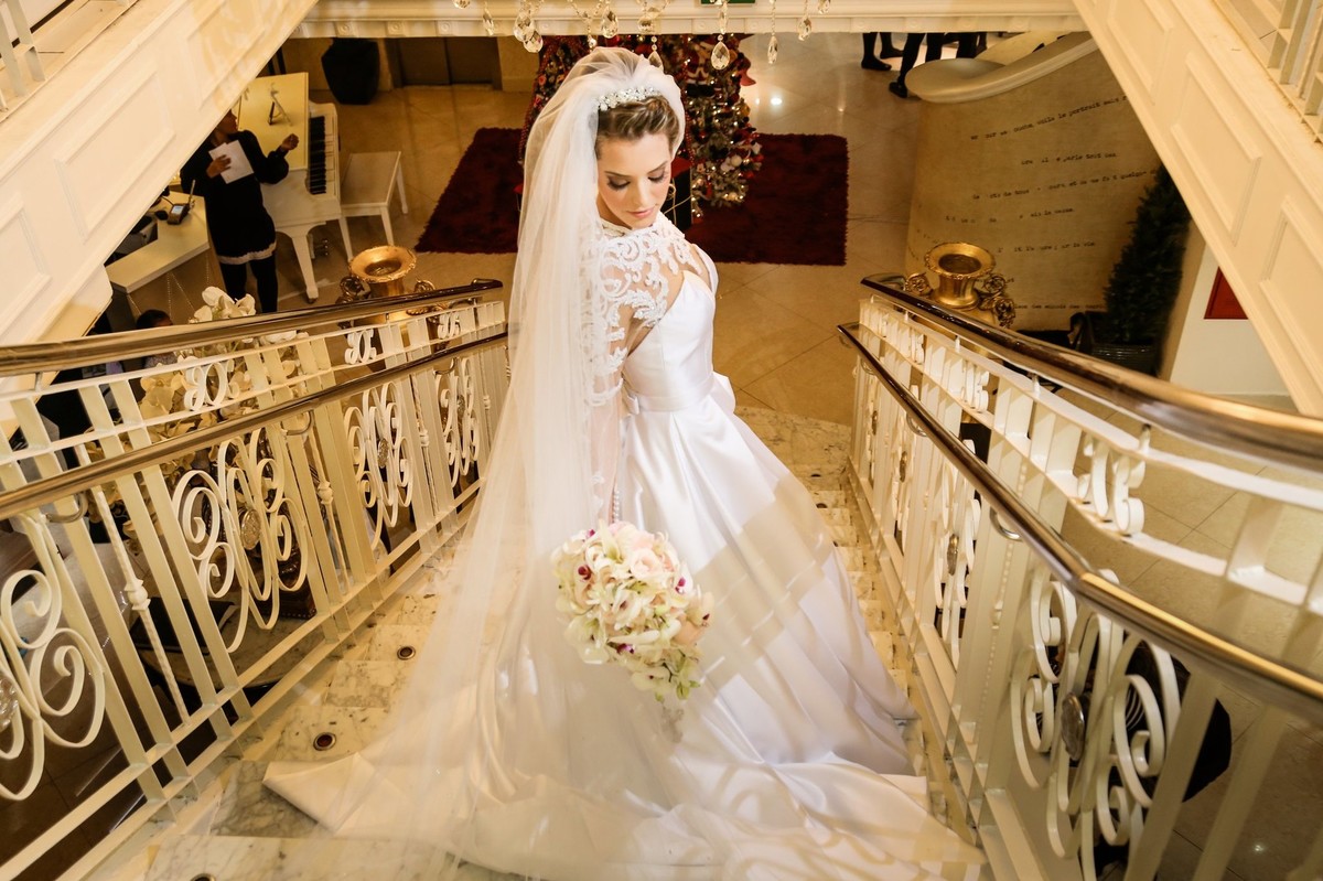 noiva com seu vestido ja com o seu buque na escada foto tirada pelo fotografo de casamento thiago alt