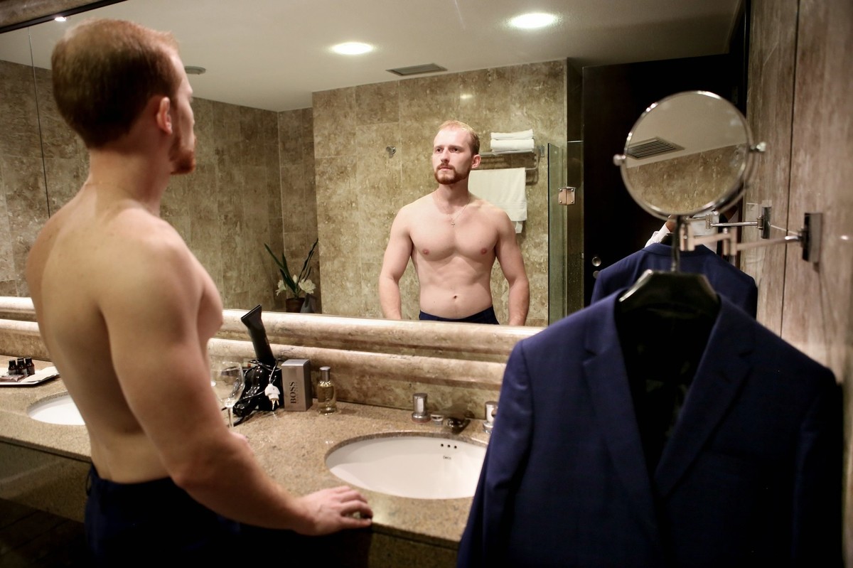 noivo sem camisa se preparando para colocar sua camisa e seu terno foto tirada pelo fotografo de casamento thiago alt