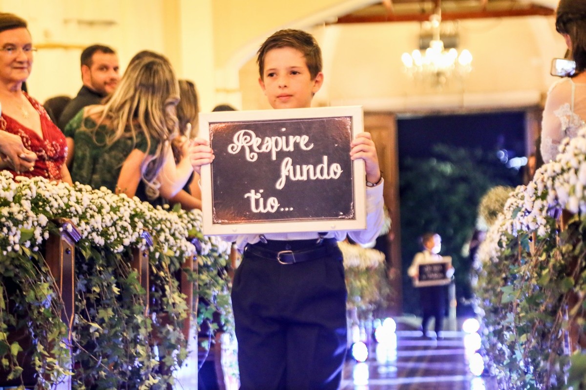 sobrinho do noivo com a plaquinha respire fundo tio na igreja do bom despacho foto tirada nas lentes do fotografo thiago alt