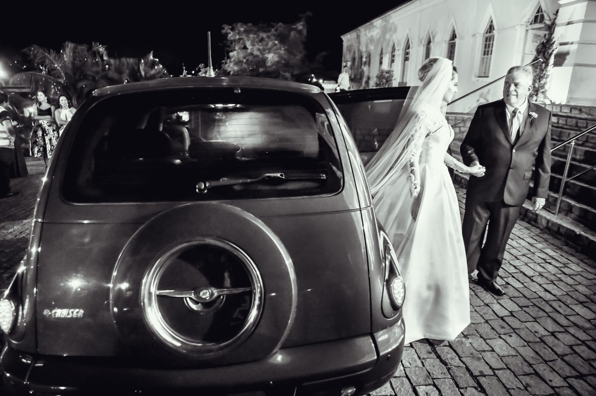 noiva saindo do carro com seu veu a mostra foto tirada nas lentes do fotografo thiago alt