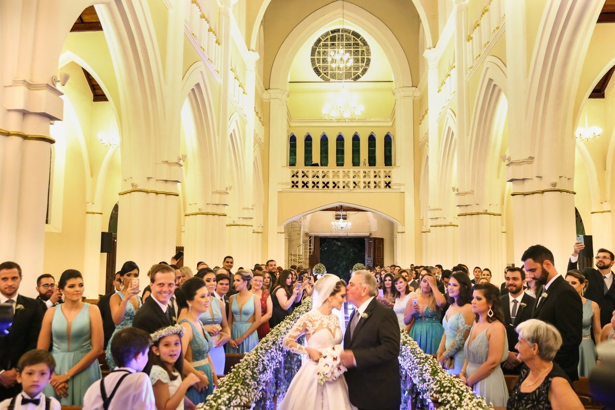 noiva sendo entregue para  o noivo pelo pai no altar foto tirada nas lentes do fotografo thiago alt