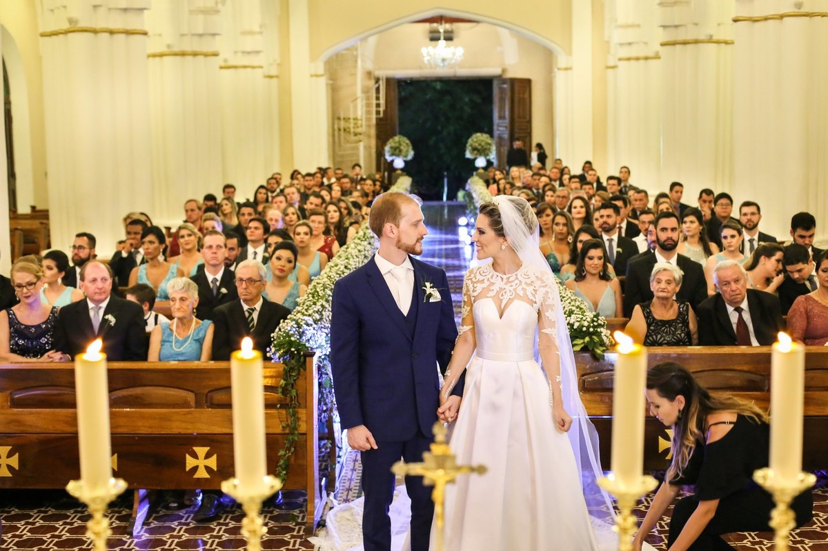 noivos no altar um olhando para o outro foto tirada nas lentes do fotografo thiago alt