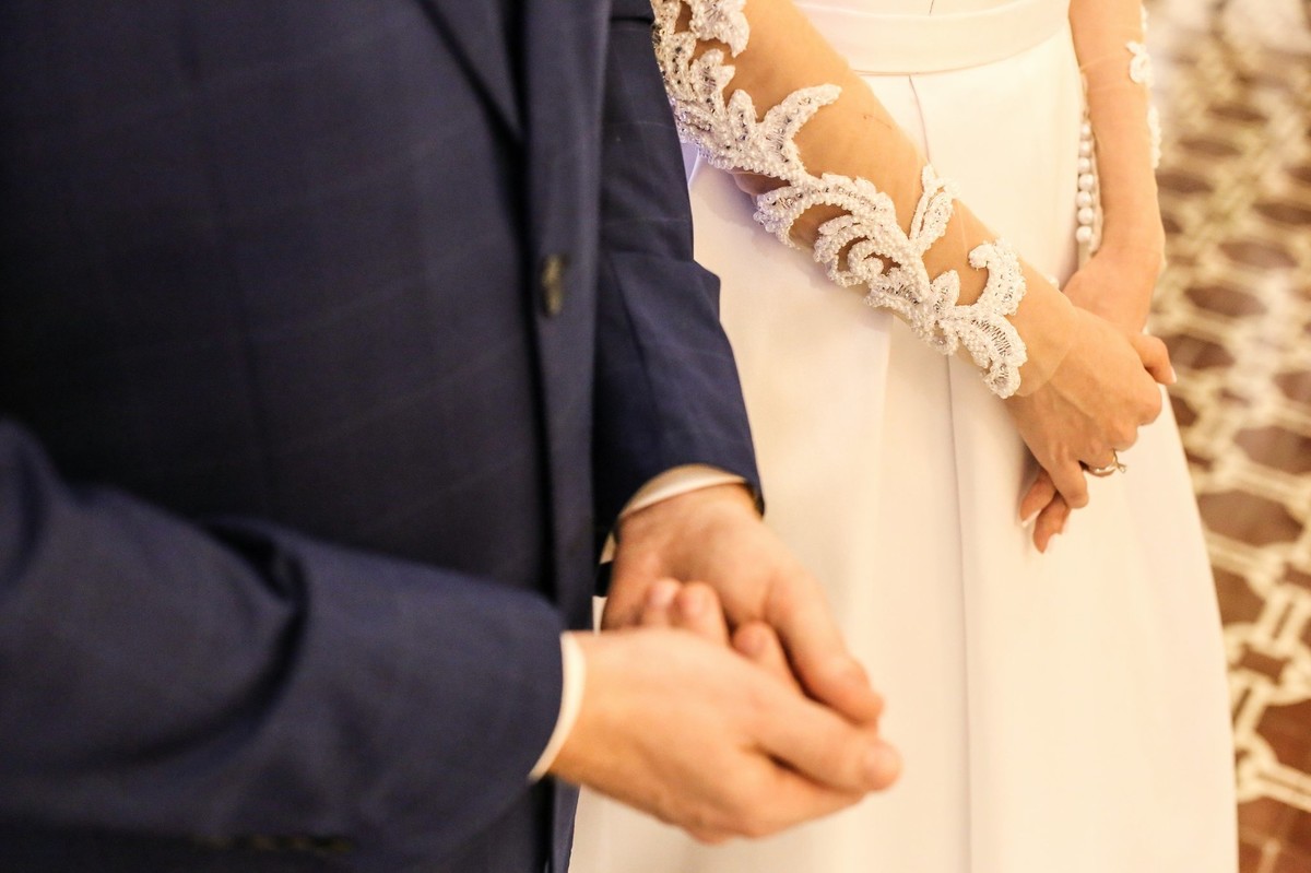 noivos ao altar sendo abencoados pelo padre na igreja do bom despacho foto tirada nas lentes do fotografo thiago alt