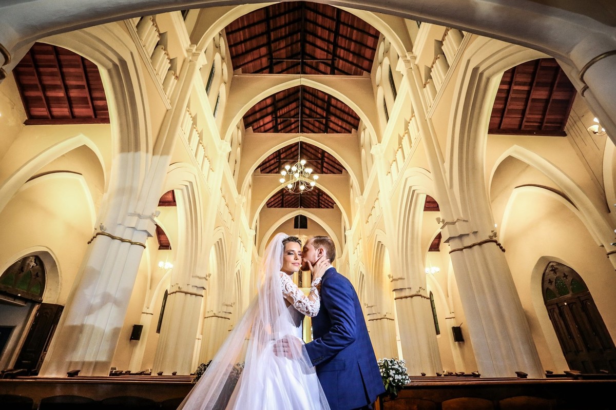 noivo beijando o rosto de sua noiva na igreja do bom despacho foto tirada nas lentes do fotografo thiago alt
