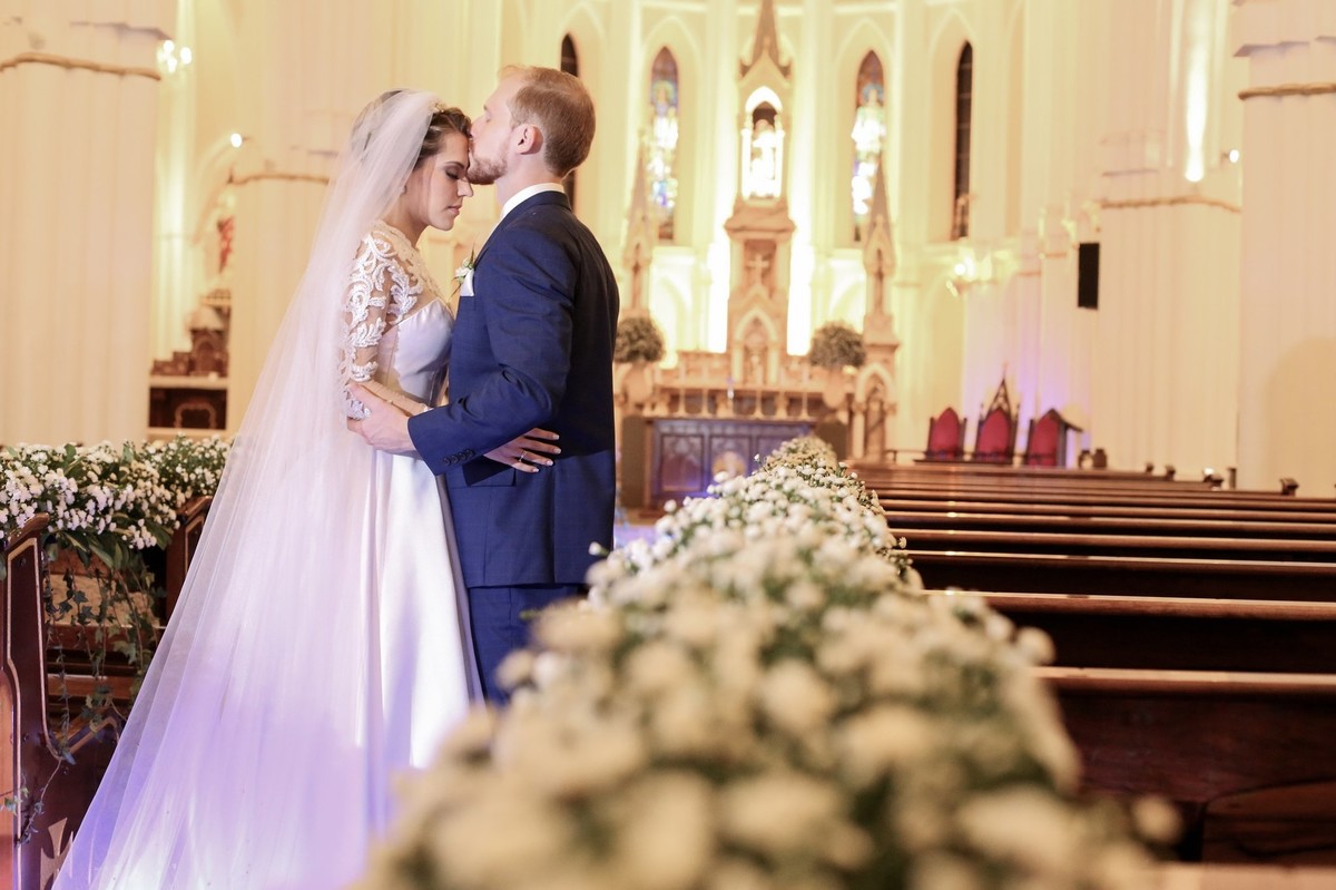 noivo beijando testa de sua noiva e estao abracados na igreja do bom despacho foto tirada nas lentes do fotografo thiago alt