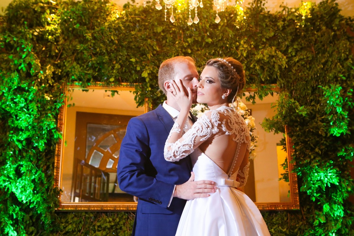 noivo beijando rosto da sua noiva foto tirada nas lentes do fotografo thiago alt