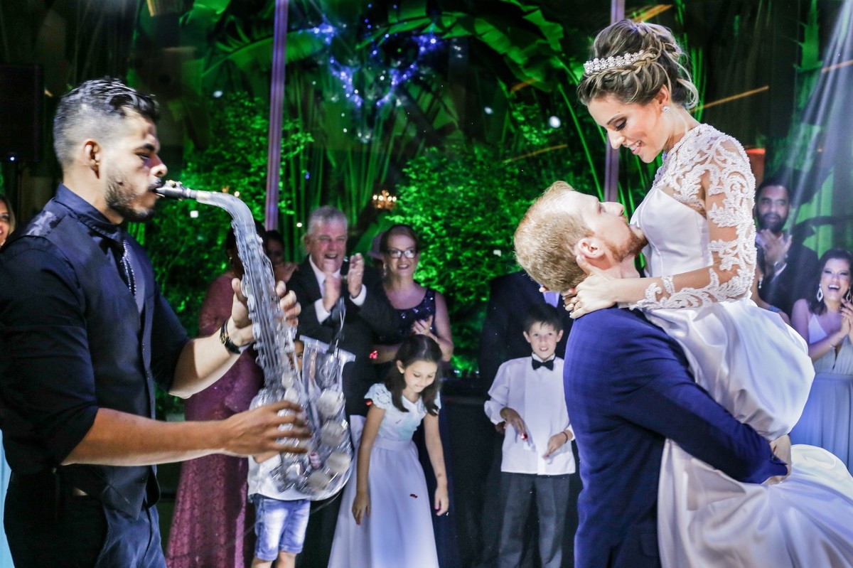 noivo pegando sua noiva no colo ao som do sax alto foto tirada nas lentes do fotografo thiago alt