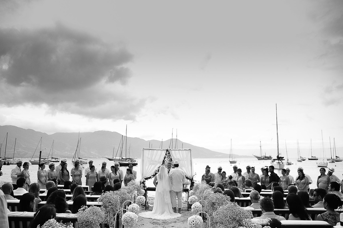 Casamento super alto astral fotografado em Ilhabela, no espaço Sea Club. Casal Renata e Leandro. Entrada da noiva. Casamento na praia. Cerimonia pé na areia.