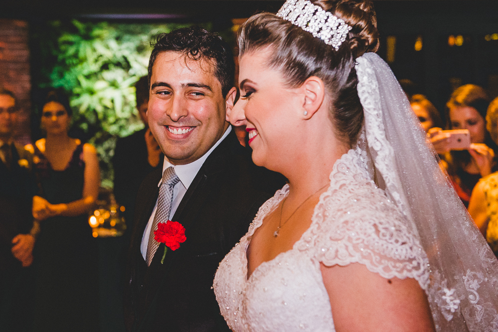 Noivos durante a cerimônia de casamento no Villa Bisutti com sua lapela de casamento e vestido de casamento