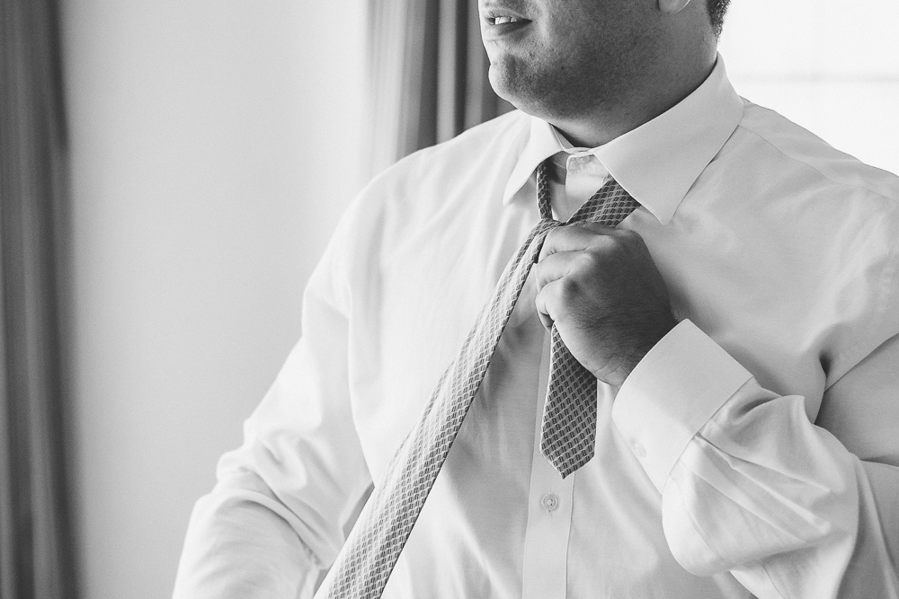 noivo arrumando gravata de casamento em seu making of no Grand Hyatt São Paulo para casamento no Villa Bisutti pelo fotógrafo de casamento Vinicius Donha