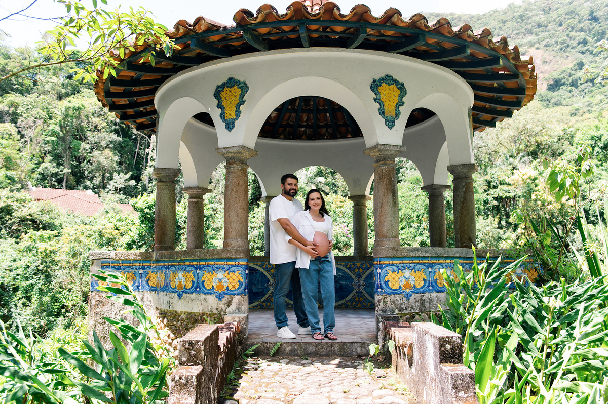 Marido e esposa grávida no coreto da Pousada Terê Parque, com vista para a natureza do Parque Nacional da Serra dos Órgãos
