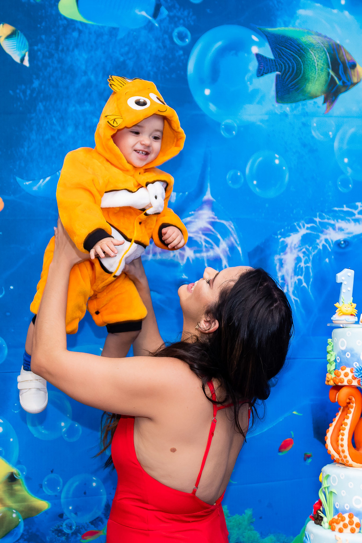 Mamãe brincando com seu filho vestido de Nemo no aniversário de 1 ano e na decoração do fundo do mar