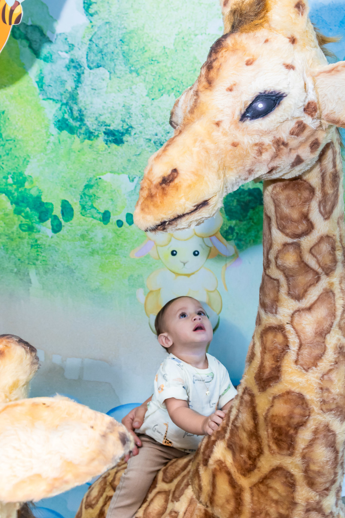 Registro perfeito do Gabriel sozinho com a girafa no cenário do seu primeiro aniversário