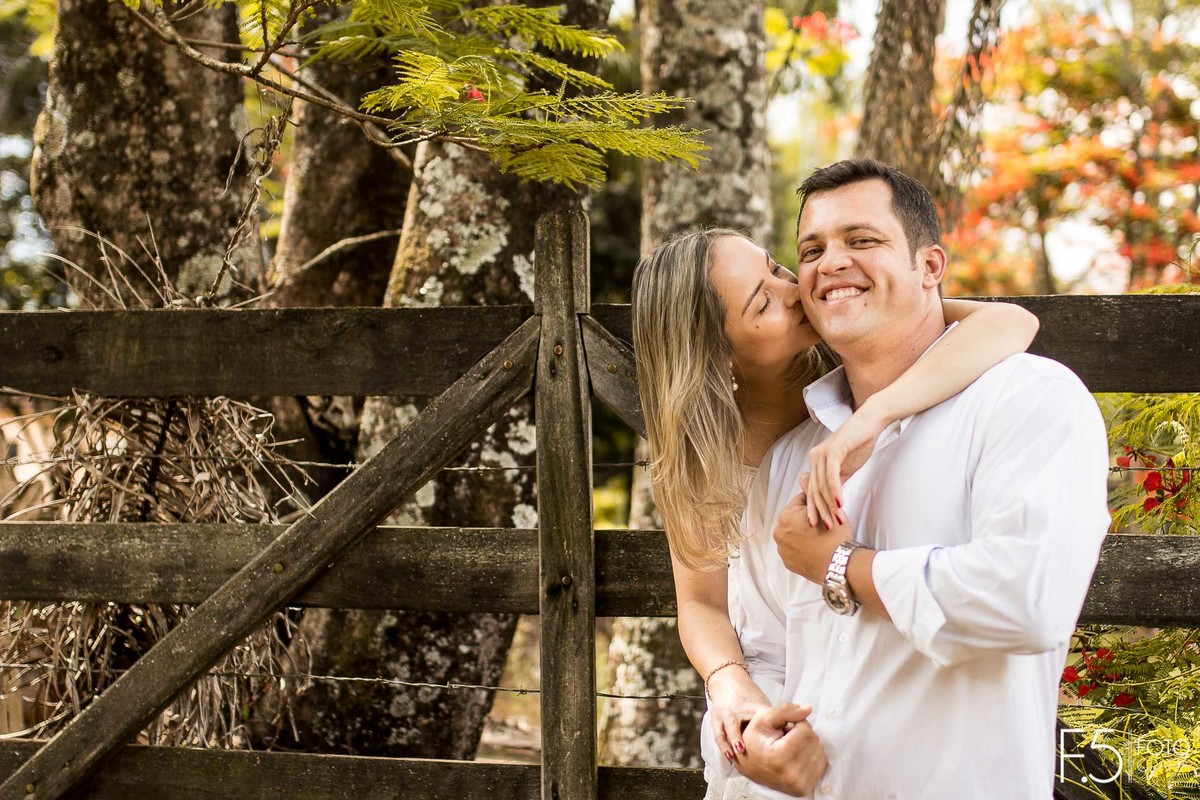 Casal de noivos, Lívia e Renato, sorrindo e dando beijo no rosto, Pré Wedding em Muzambinho - MG.